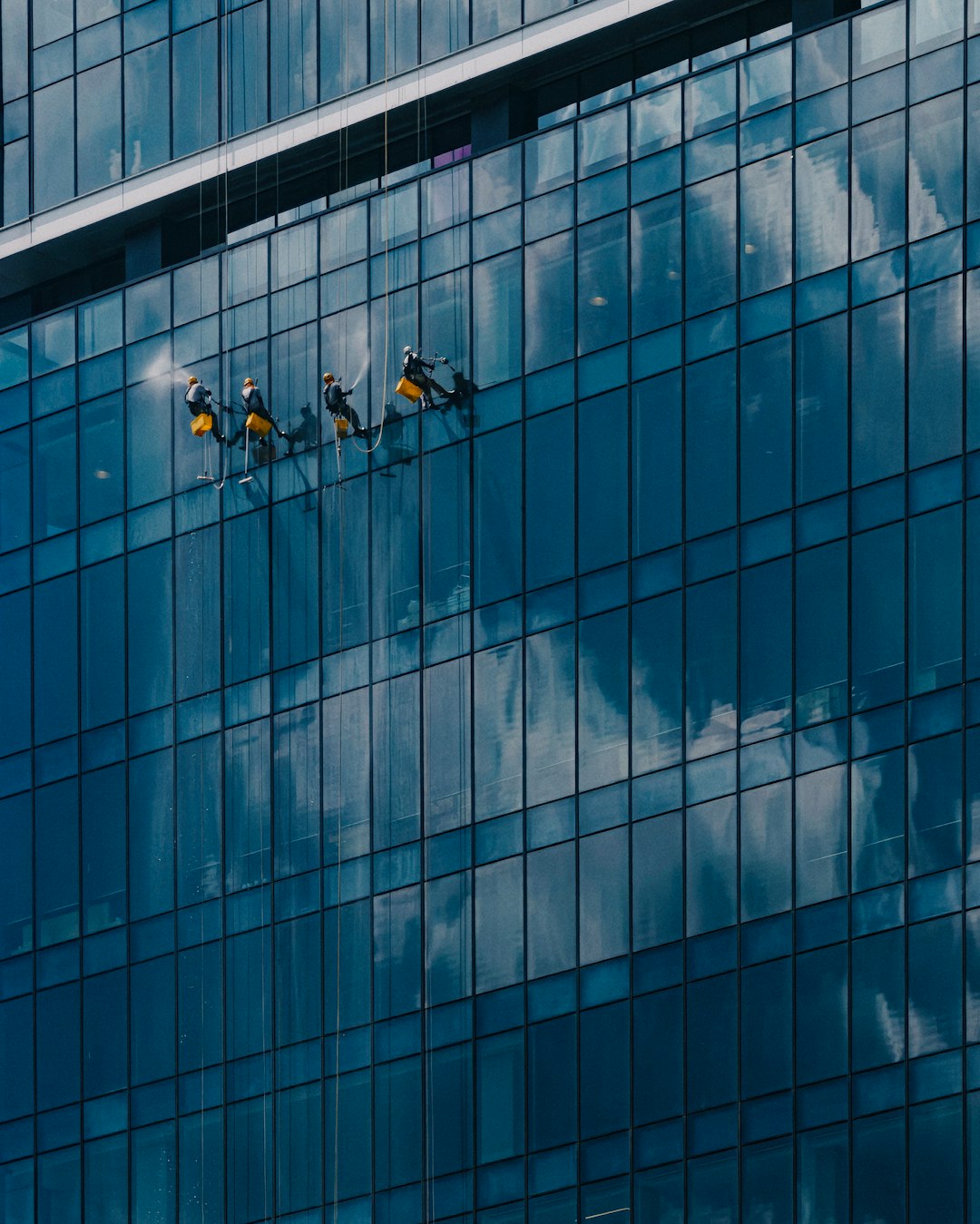 Window cleaner using a squeegee on a glass facade